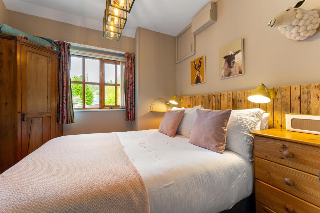 una camera da letto con un letto grande e una finestra di Romantic, secluded cottage in Cardinham Woods, Cornwall a Cardinham