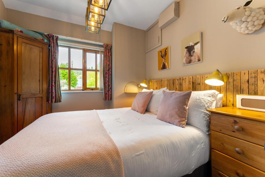 a bedroom with a large bed and a window at Romantic, secluded cottage in Cardinham Woods, Cornwall in Cardinham