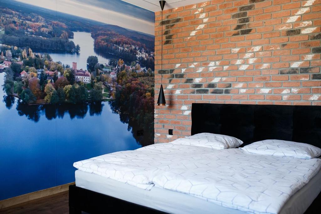 um quarto com uma parede de tijolos e uma cama com um mural em Agroturystyka Pod Dębem em Łagów