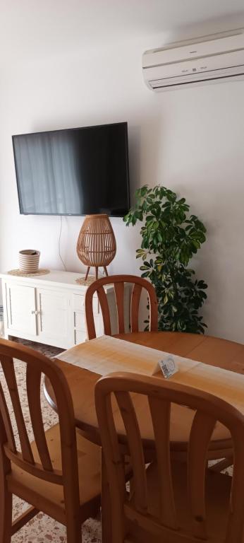 a dining room table with two chairs and a television at Hotel Nou Can Guillem in Cala Figuera