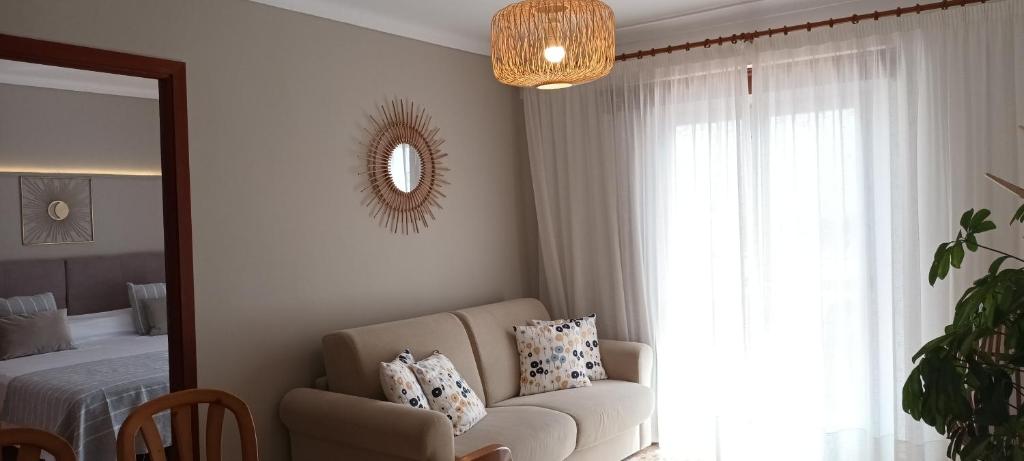 a living room with a couch and a mirror at Hotel Nou Can Guillem in Cala Figuera
