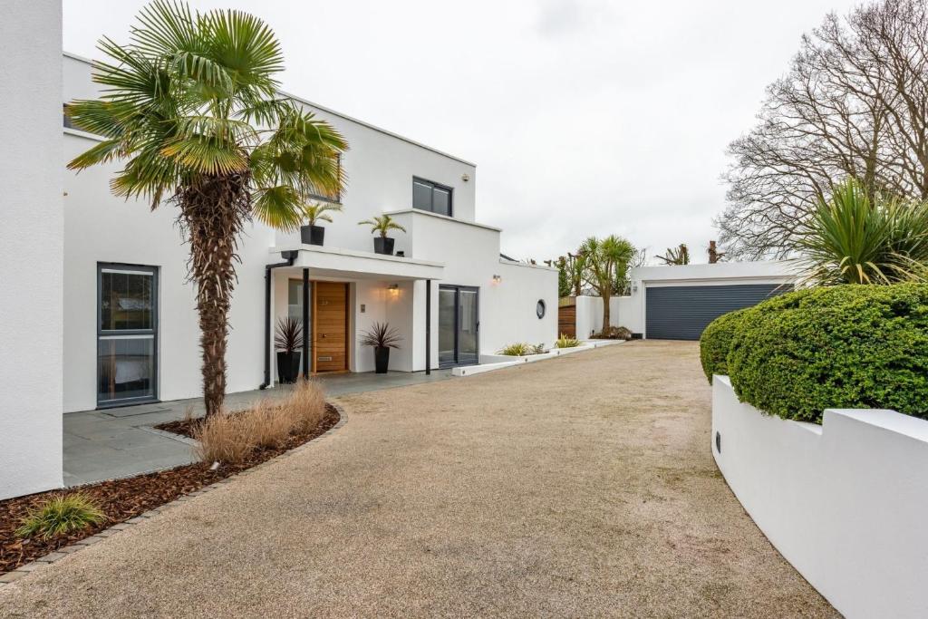a white house with a palm tree in the driveway at The Crewhouse in Hamble