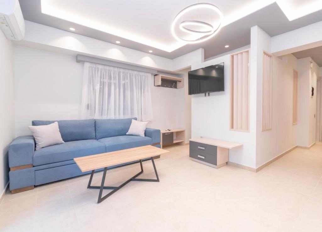 een woonkamer met een blauwe bank en een tafel bij SithoniaRS Luxury Ground Floor Apartment With Private Garden in Neos Marmaras