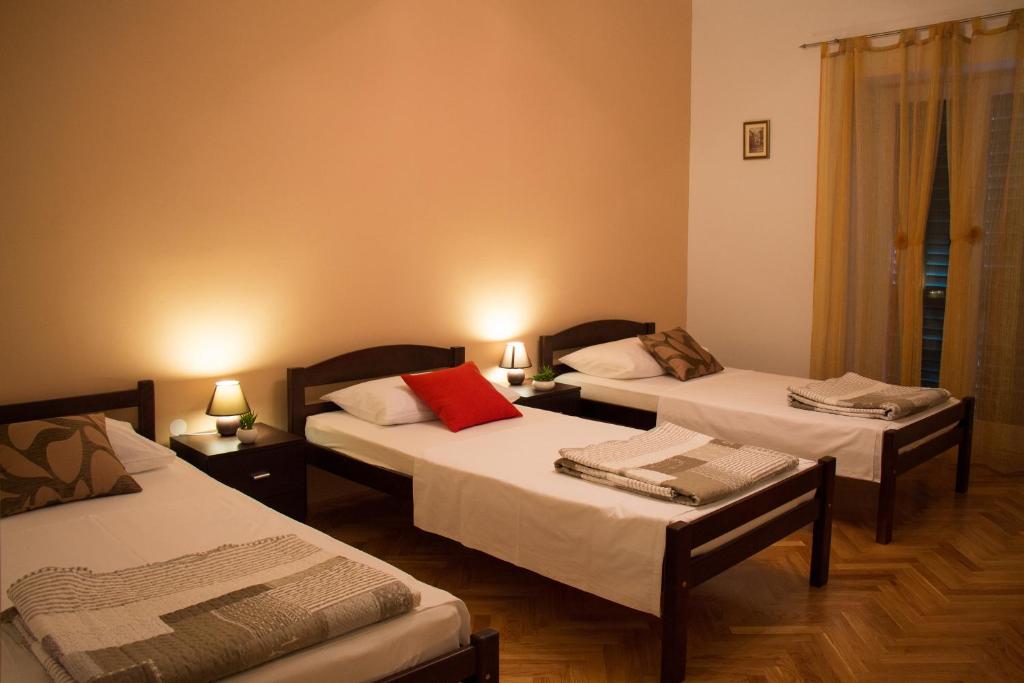 een kamer met 2 bedden en 2 tafels met lampen bij Apartment Leatoni in Split
