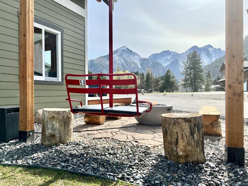 a red bench sitting on a patio with mountains in the background at The Cascade Chalet - Leavenworth in Leavenworth