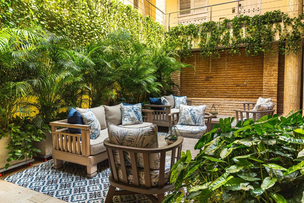 eine Terrasse mit Stühlen, Bäumen und Pflanzen in der Unterkunft Hotel Casa Canabal by Faranda Boutique in Cartagena de Indias