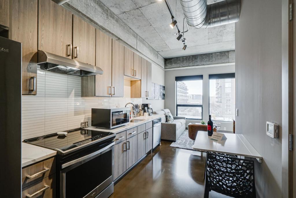 明尼阿波利斯的住宿－Sable 32，厨房配有木制橱柜和桌子。