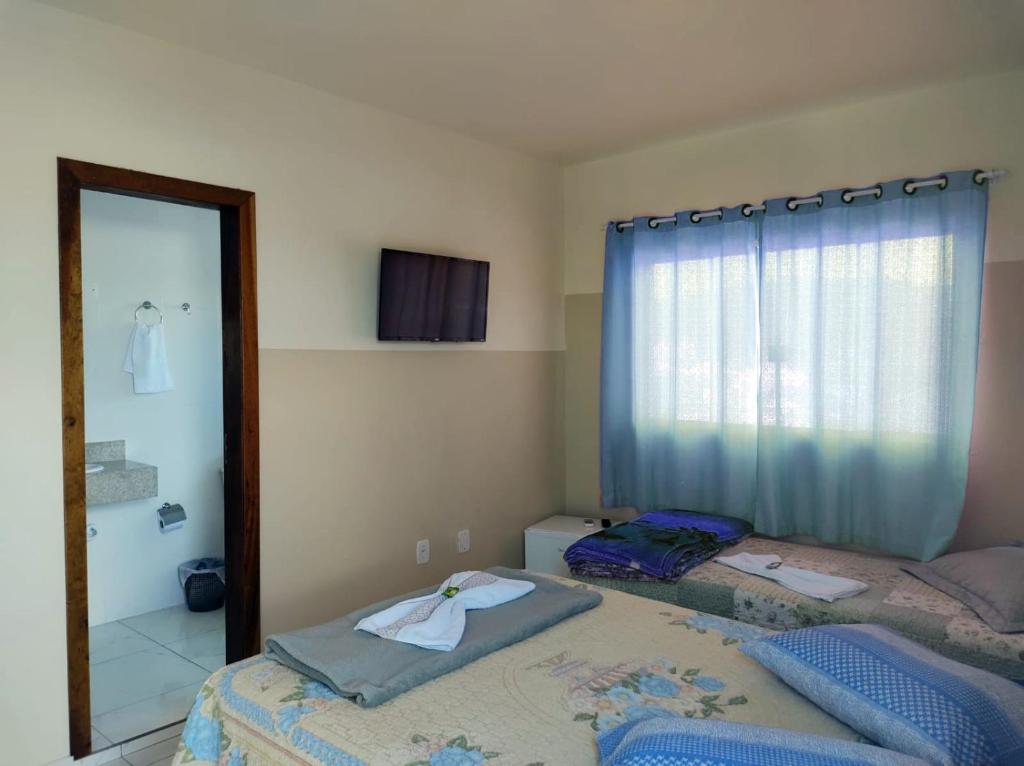 um quarto com 2 camas individuais e um espelho em Hotel Janaína em Porto Belo