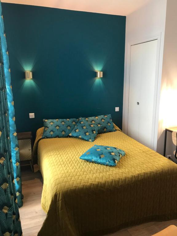 a bedroom with two beds and a blue wall at Les Pastels in La Roche-sur-Yon