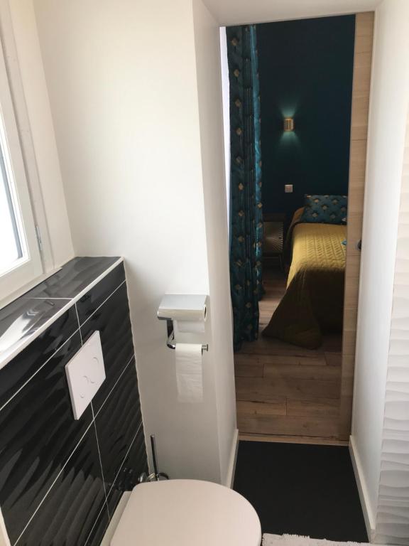 a small bathroom with a toilet and a bedroom at Les Pastels in La Roche-sur-Yon