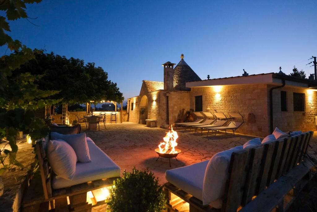 a patio with a fire pit and chairs and a building at Trullo Natù in Alberobello