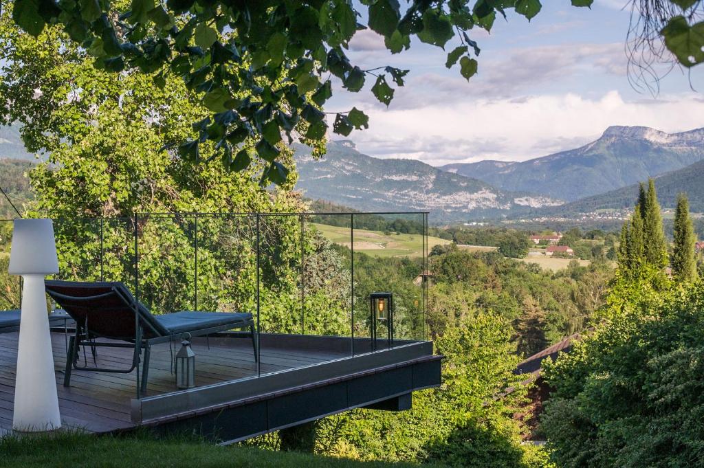 une chaise sur une terrasse avec vue sur les montagnes dans l'établissement LA Villa Du Lac, à Annecy