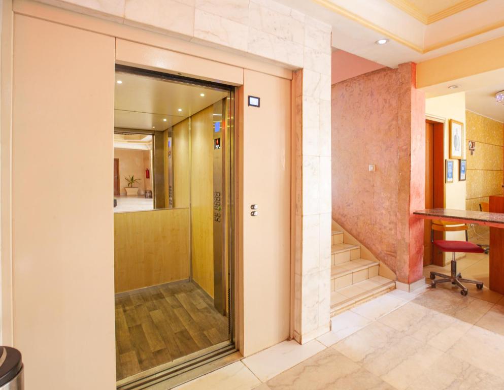 uma porta de vidro que dá para um corredor com uma escada em FELICIA HOTEL YAOUNDE em Iaundé