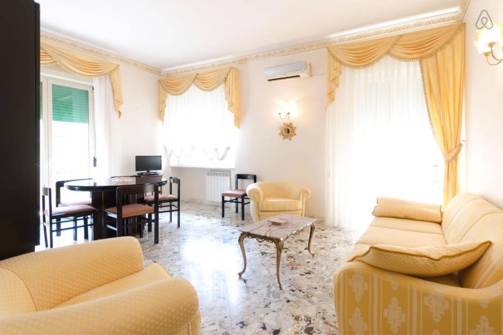 a living room with yellow furniture and a table at Appartamento Vacanze Taormina in Taormina