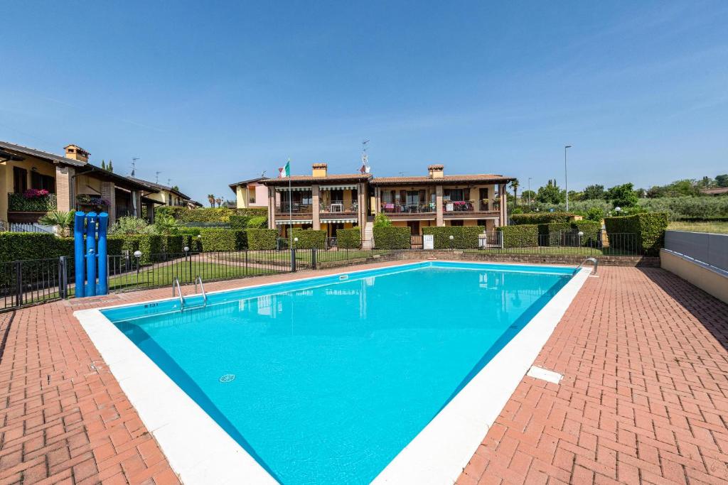 a swimming pool in front of a house at Al Tulipano in Polpenazze del Garda
