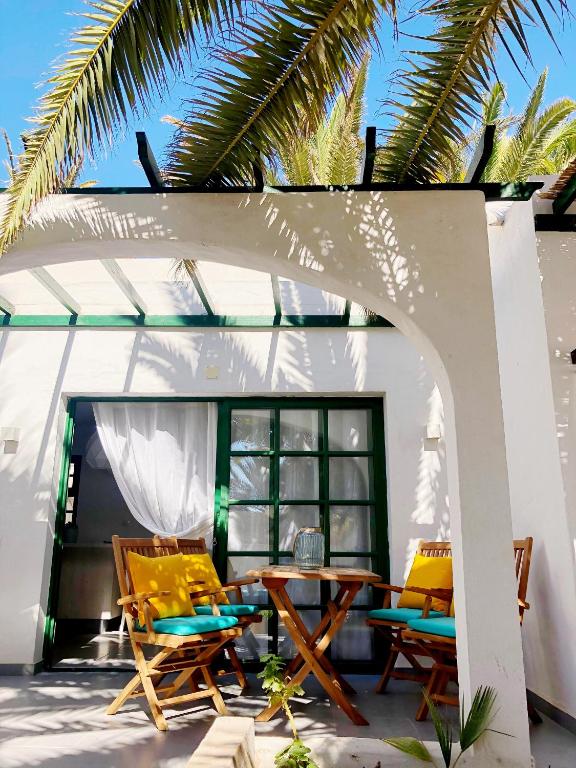a patio with a table and chairs under a pergola at Casita Vito Fuerteventura in Costa Calma