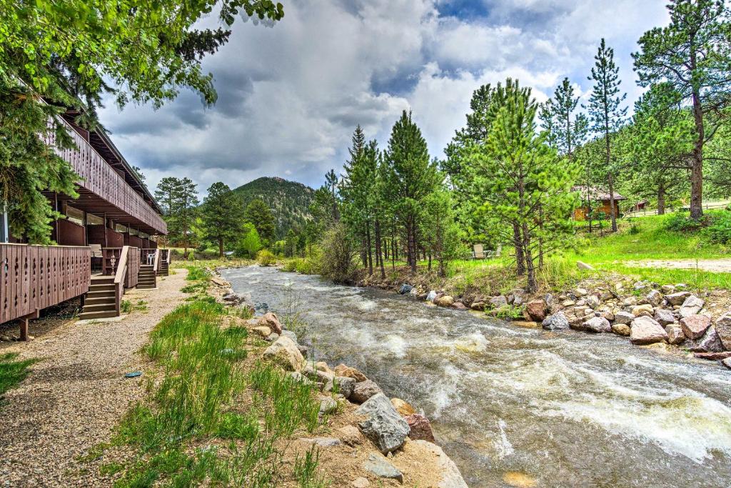 a river next to a building next to a river at Cozy Condo on Fall River - 1 Mile to RMNP Gate! in Estes Park