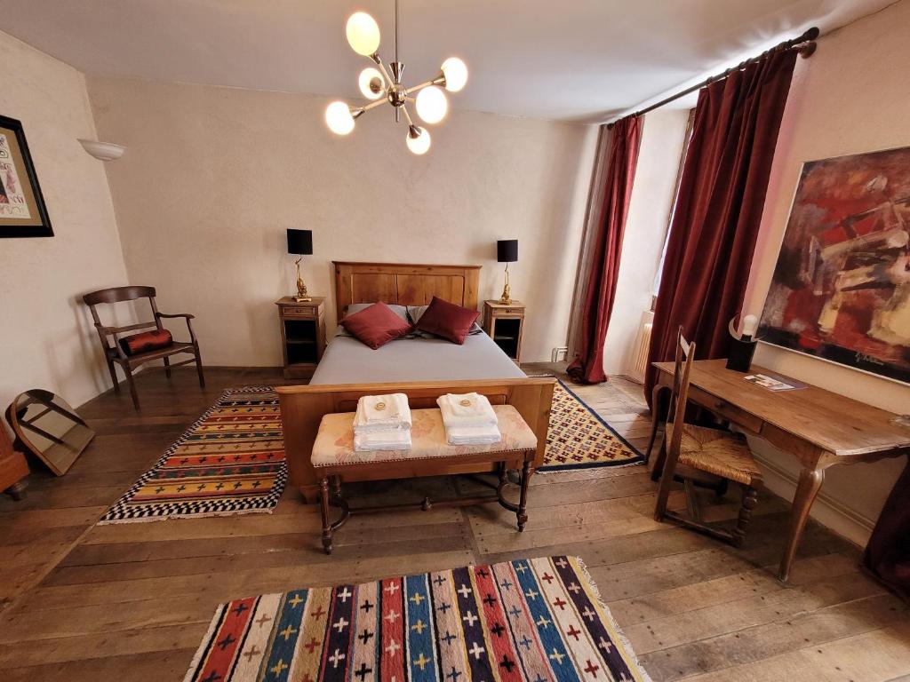 1 dormitorio con cama, mesa y escritorio en La Cressonnière, en Parthenay