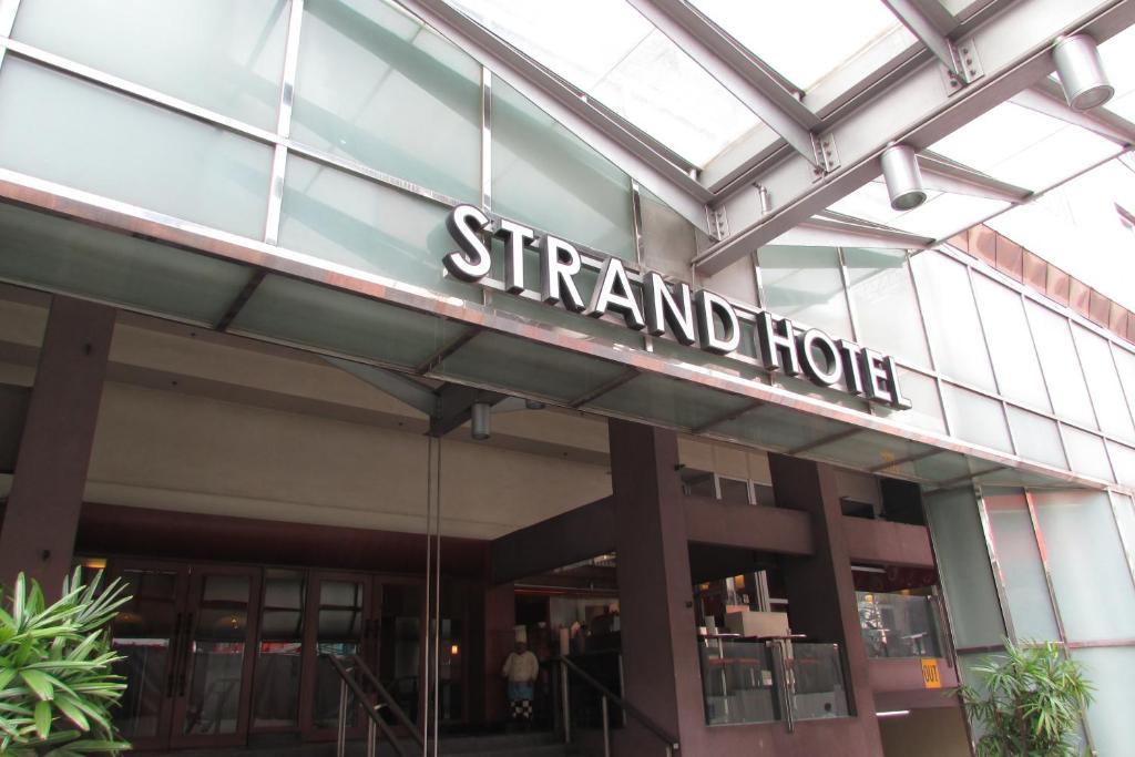 um sinal na lateral de um edifício em Strand Hotel em Singapura