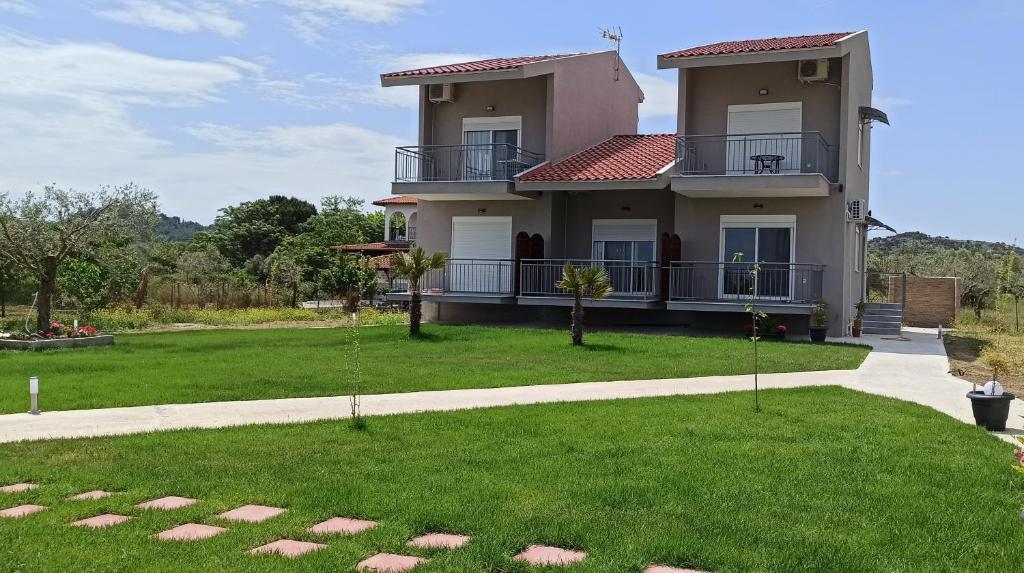 a house with a green lawn in front of it at Vot villas in Ormos Panagias