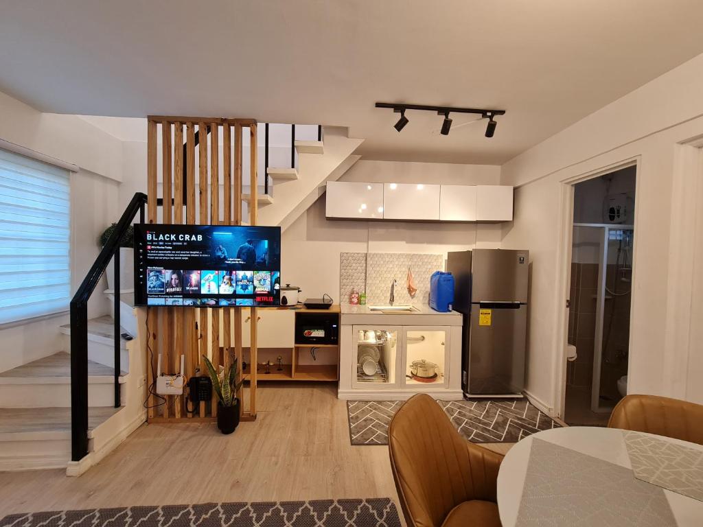 ein Wohnzimmer mit einer Treppe und eine Küche in der Unterkunft Mc Residence 6 w/ Netflix,100Mbps wifi&hot shower in General Santos