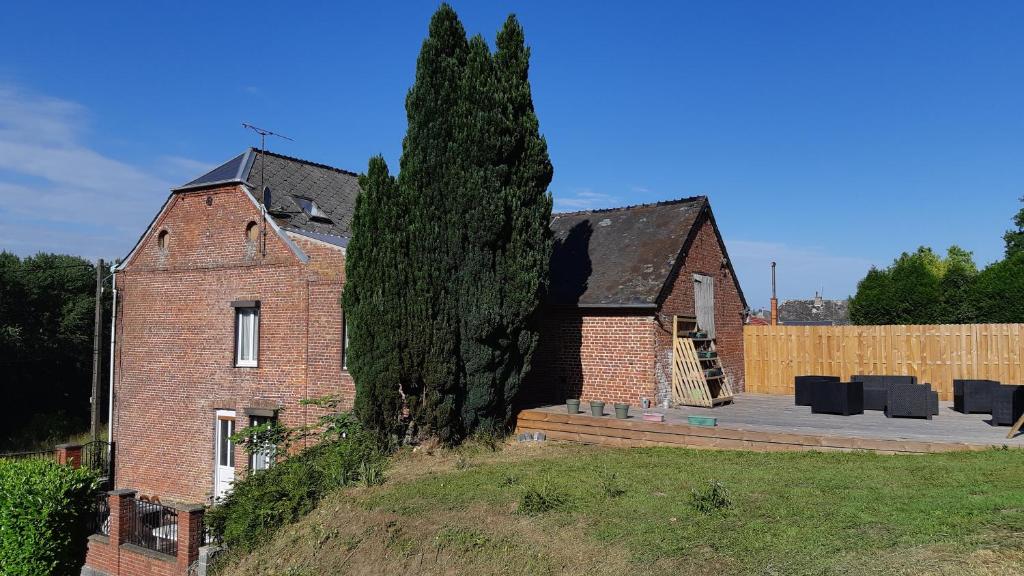una casa de ladrillo con un árbol delante de ella en Les Hauts de Proisy, en Proisy