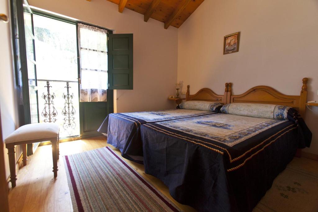 a bedroom with a bed and a large window at Casa Rural Camangu in Camango