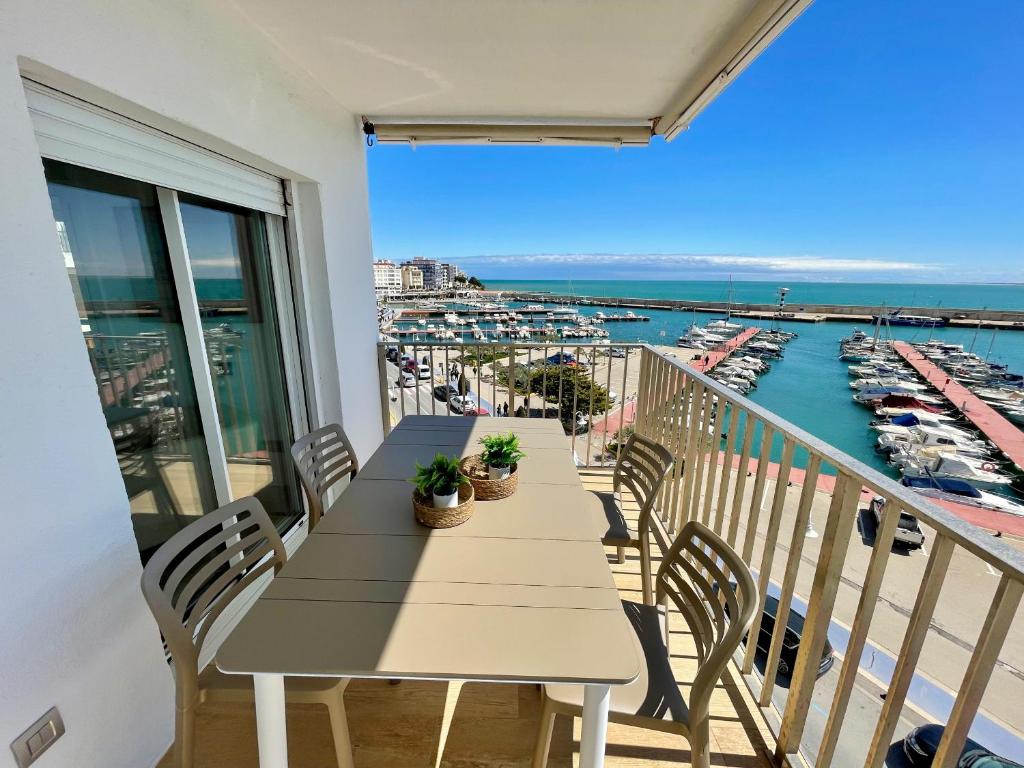 a table on a balcony with a view of a marina at Apto Panoramic in L'Ampolla
