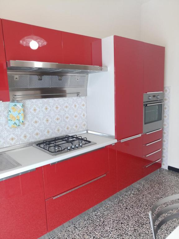 een keuken met rode kasten en een kookplaat oven bij Interno2 in Diano Marina