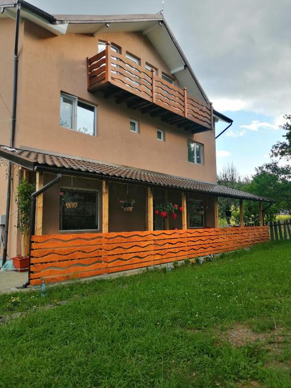 a large house with a balcony on top of it at Casa Gramy in Neagra Şarului