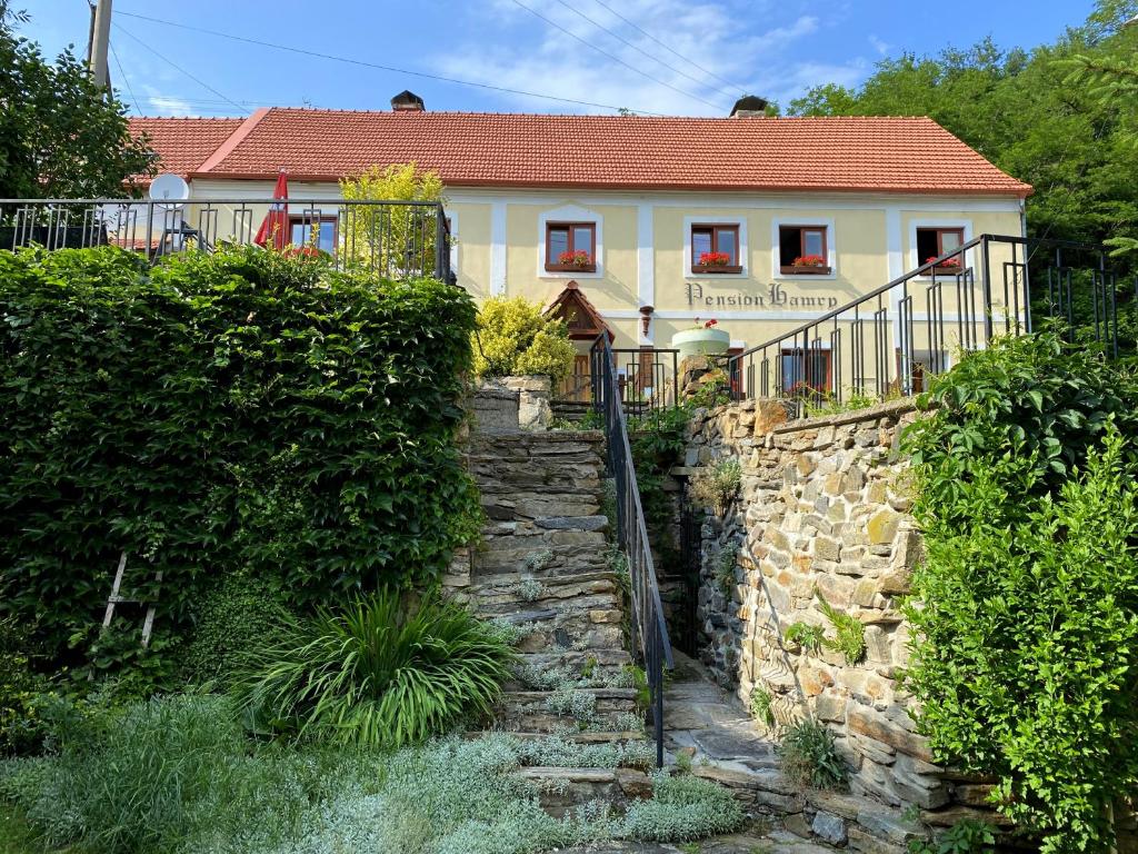 una casa con un camino de piedra frente a un edificio en Pension Hamry, en Vranov nad Dyjí
