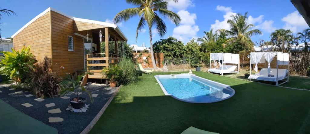 a backyard with a swimming pool and a house at Villa Rosa Karibella in Saint-François