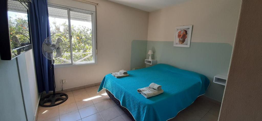 Un dormitorio con una cama azul y una ventana en Departamentos Saavedra dto A y B en Viedma