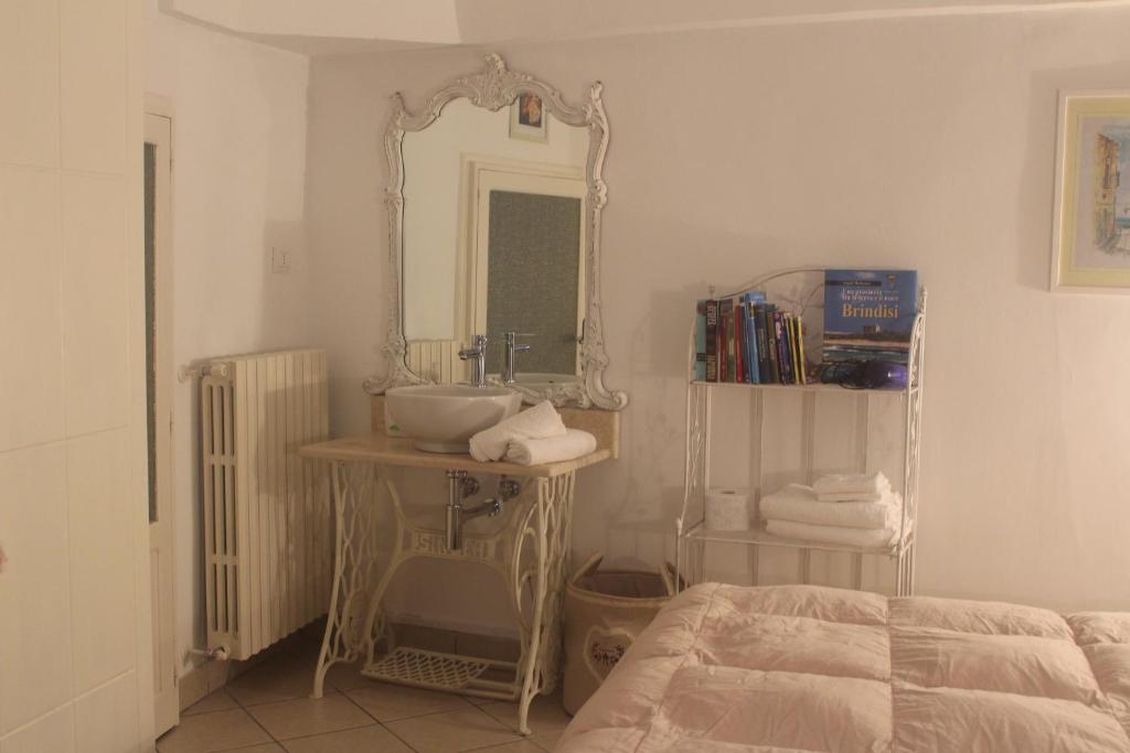 La salle de bains est pourvue d'un lavabo et d'un miroir. dans l'établissement Dimora "Bianca Ostuni", à Ostuni