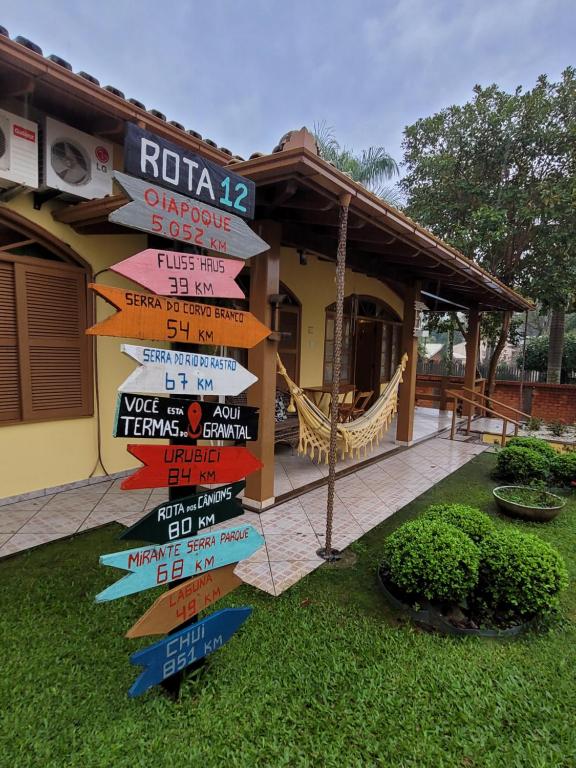 a directional sign in front of a house at Pousada Bella Vista in Gravatal