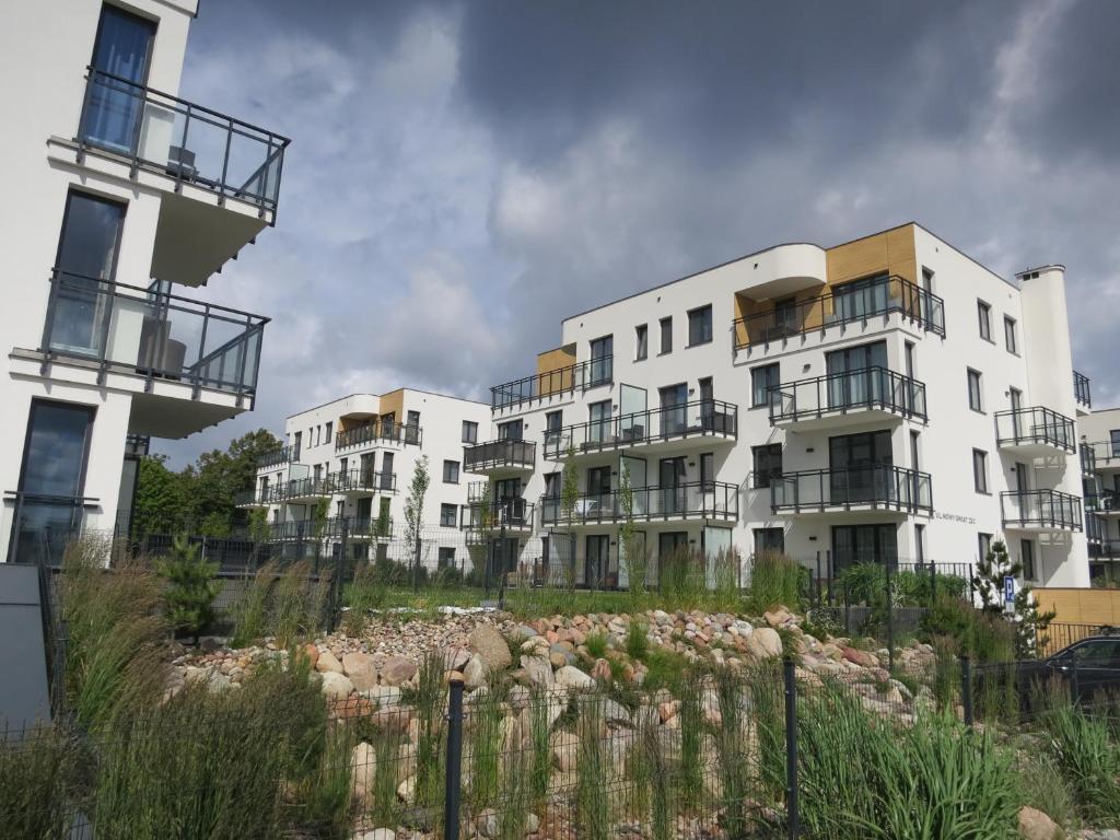 a row of white apartment buildings with balconies at Studio Verdemar Nexo in Puck