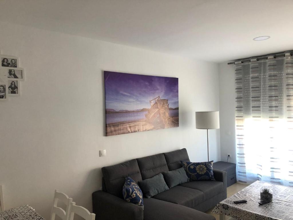 una sala de estar con sofá y una pintura en la pared en Apartamento Paraíso, en Garrucha