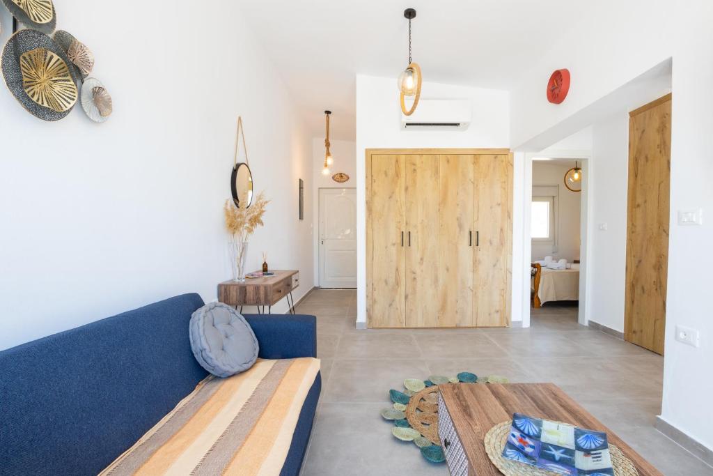 un soggiorno con divano blu e porta in legno di Aronia Luxury Apartments Karpathos a Karpathos