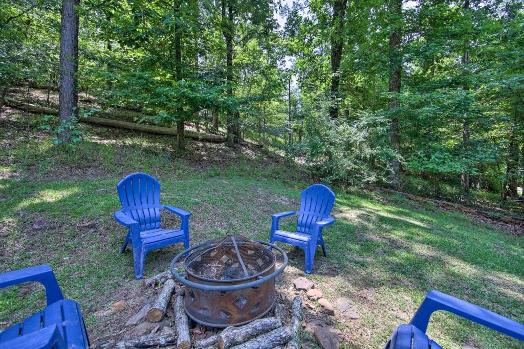 dos sillas azules y una hoguera en un patio en Cozy Studio Cabin on Lake O the Pines with Deck!, en Avinger