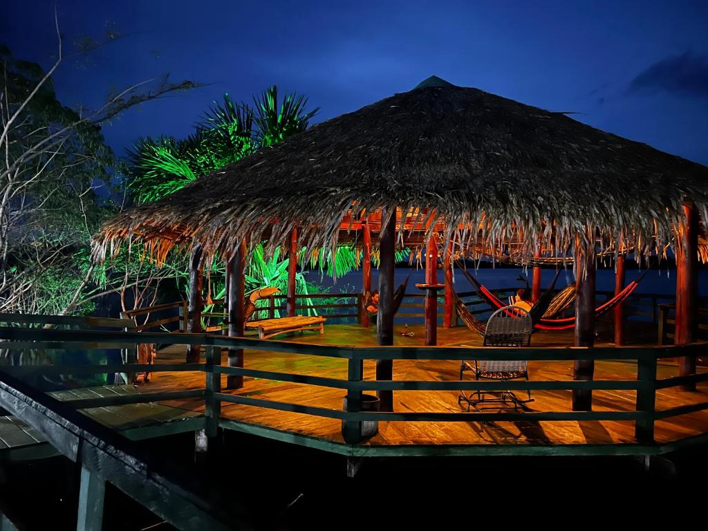 ein Resort mit Strohdach und Stühlen am Strand in der Unterkunft Amazônia LODGE Exxperience in Cajual