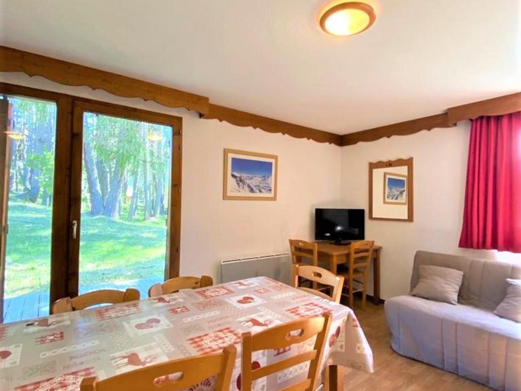 un salon avec une table et un canapé dans l'établissement Chalet 8 pers avec terrasse, local ski, parking gratuit, animaux acceptés - FR-1-504-5, à Saint-Étienne-en-Dévoluy