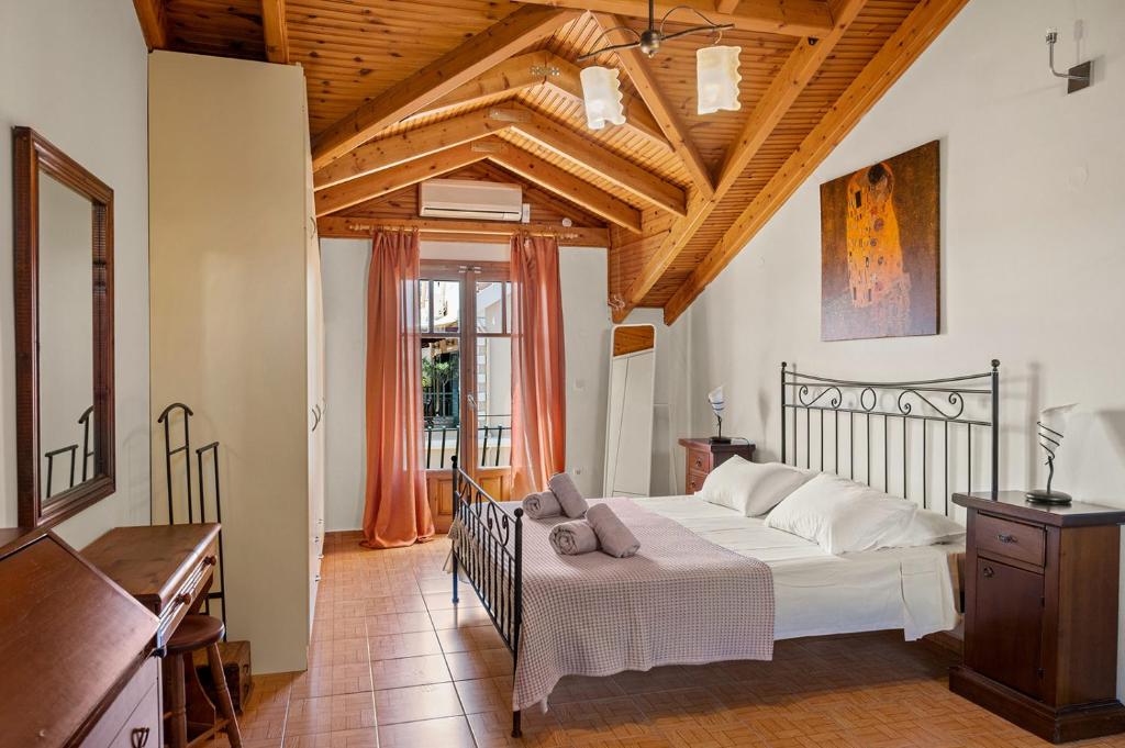 a bedroom with a white bed and a wooden ceiling at La Casetta in Argostoli