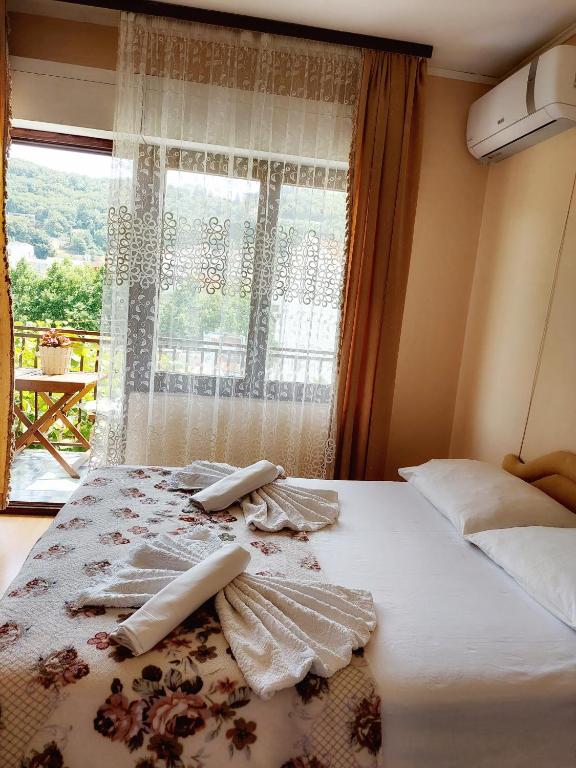 a bedroom with a bed with a window at Guesthouse DONA in Ulcinj