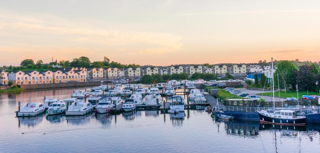 un grupo de barcos atracados en un puerto deportivo con casas en Five bedroom waterfront house, en Carrick on Shannon