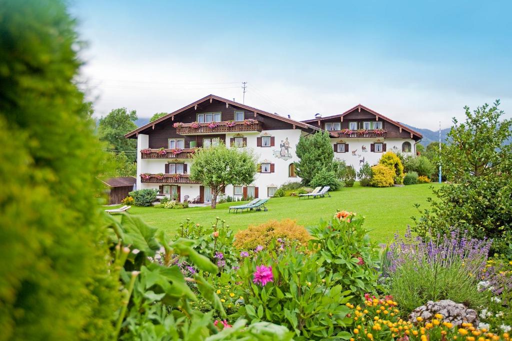 ein großes Gebäude mit einem Garten davor in der Unterkunft Gästehaus Heimgarten in Bad Wiessee