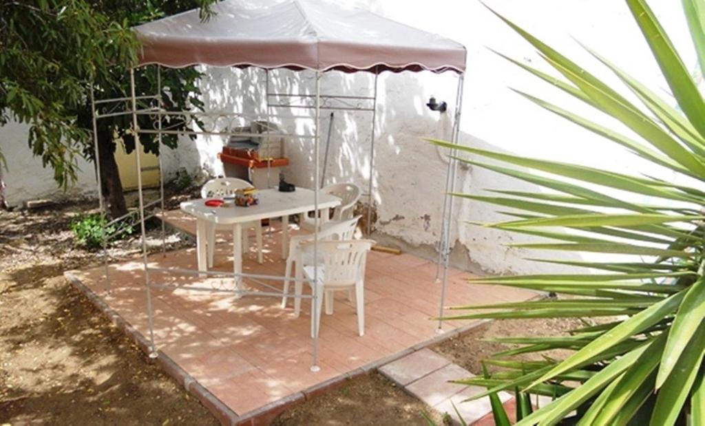 una mesa blanca y sillas debajo de una tienda en Apartment Da Mario, en Santa María