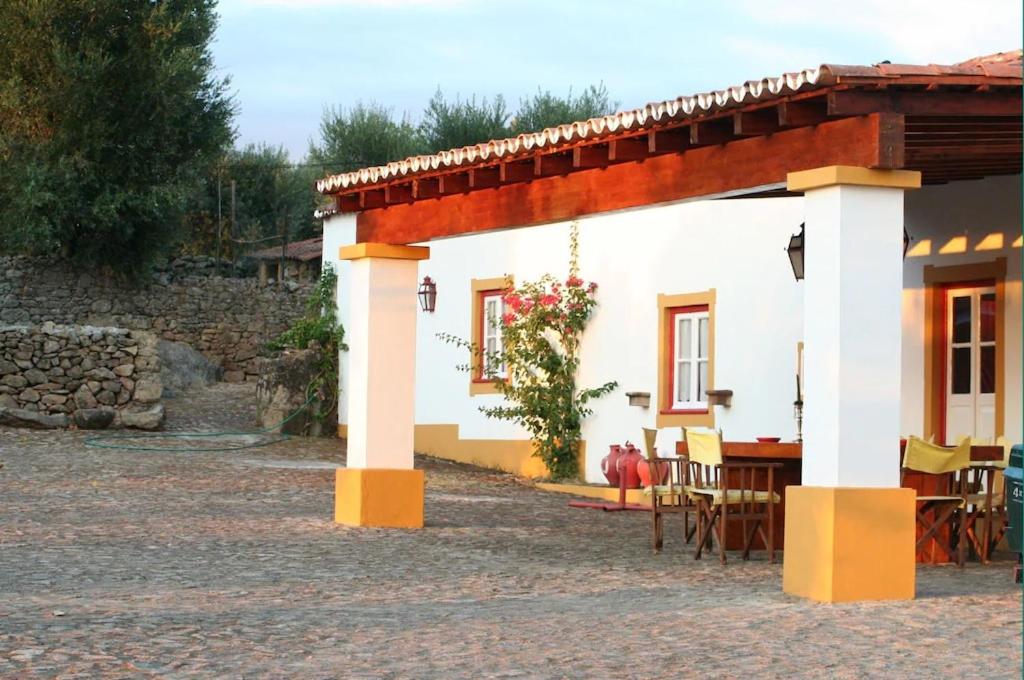 un pequeño edificio blanco con mesa y sillas en Monte da Tarouca no Alto Alentejo, en Portalegre