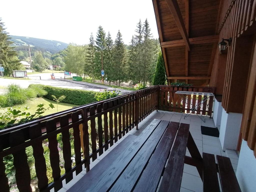 a porch with a wooden bench on a balcony at Apartmány 670 pod Lysou horou in Rokytnice nad Jizerou