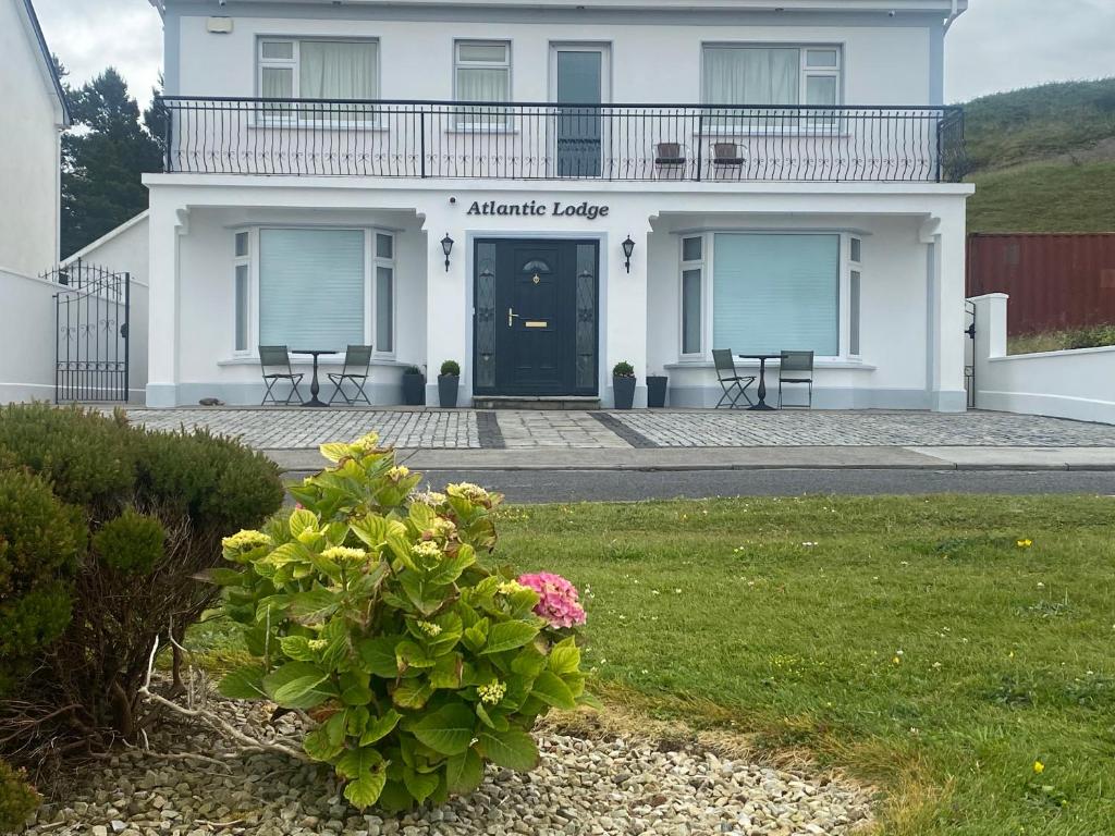 a white building with a porch and a balcony at Atlantic Lodge in Galway