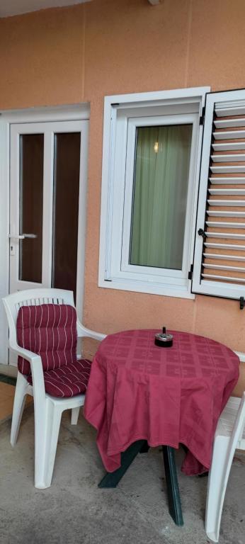 uma mesa e uma cadeira e uma mesa e uma janela em DVOKREVETNA SOBA SA KUPAONICOM em Vodice